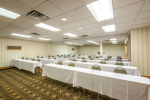 rows of tables and chairs in the meeting room at Ramada by Wyndham North Platte